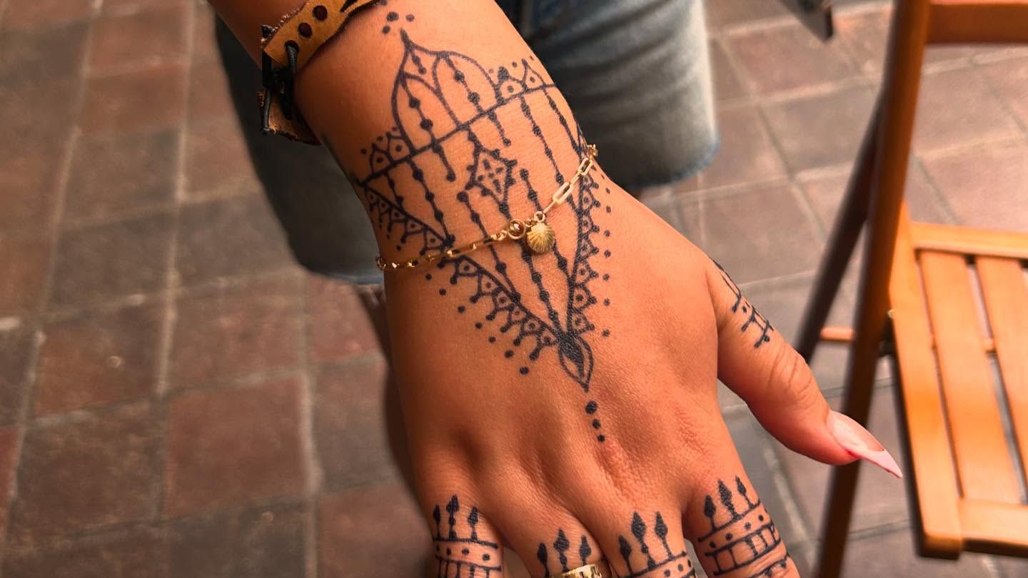 Two wrists resting together, each wearing a matching welded gold chain bracelet